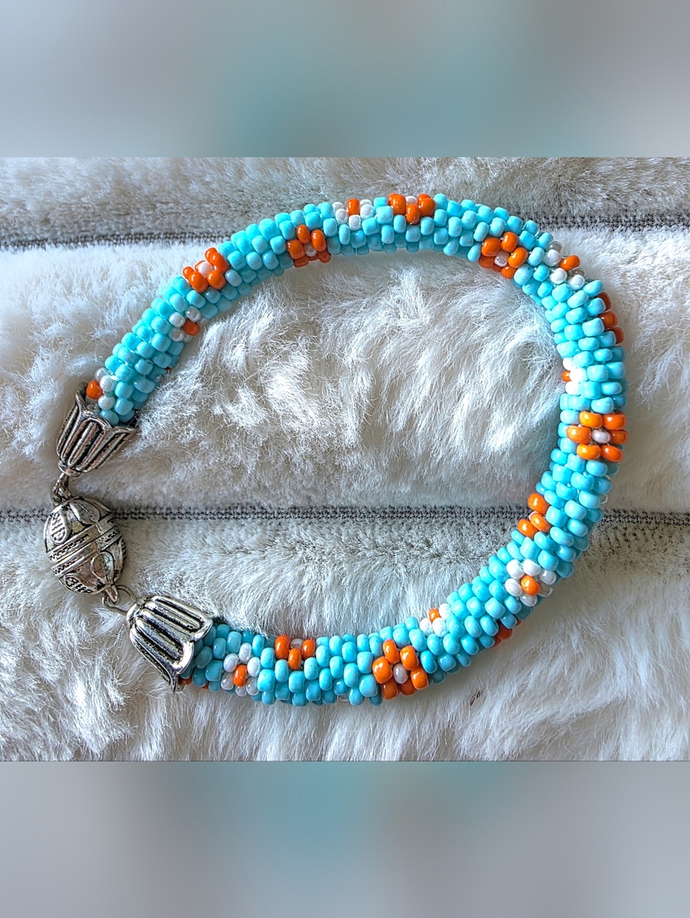 Artisan made Sead bead rope bracelet Of light blue, orange, and white floral